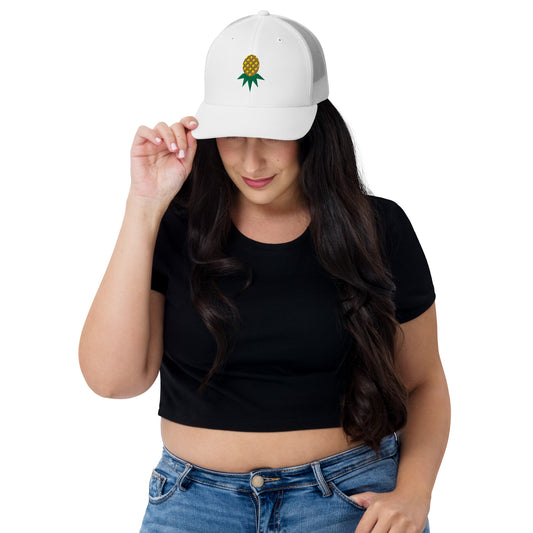 White mesh-back trucker hat with embroidered upside-down pineapple, front view on model